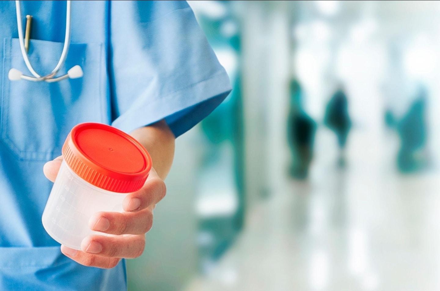 Medical professional holding a specimen collection container